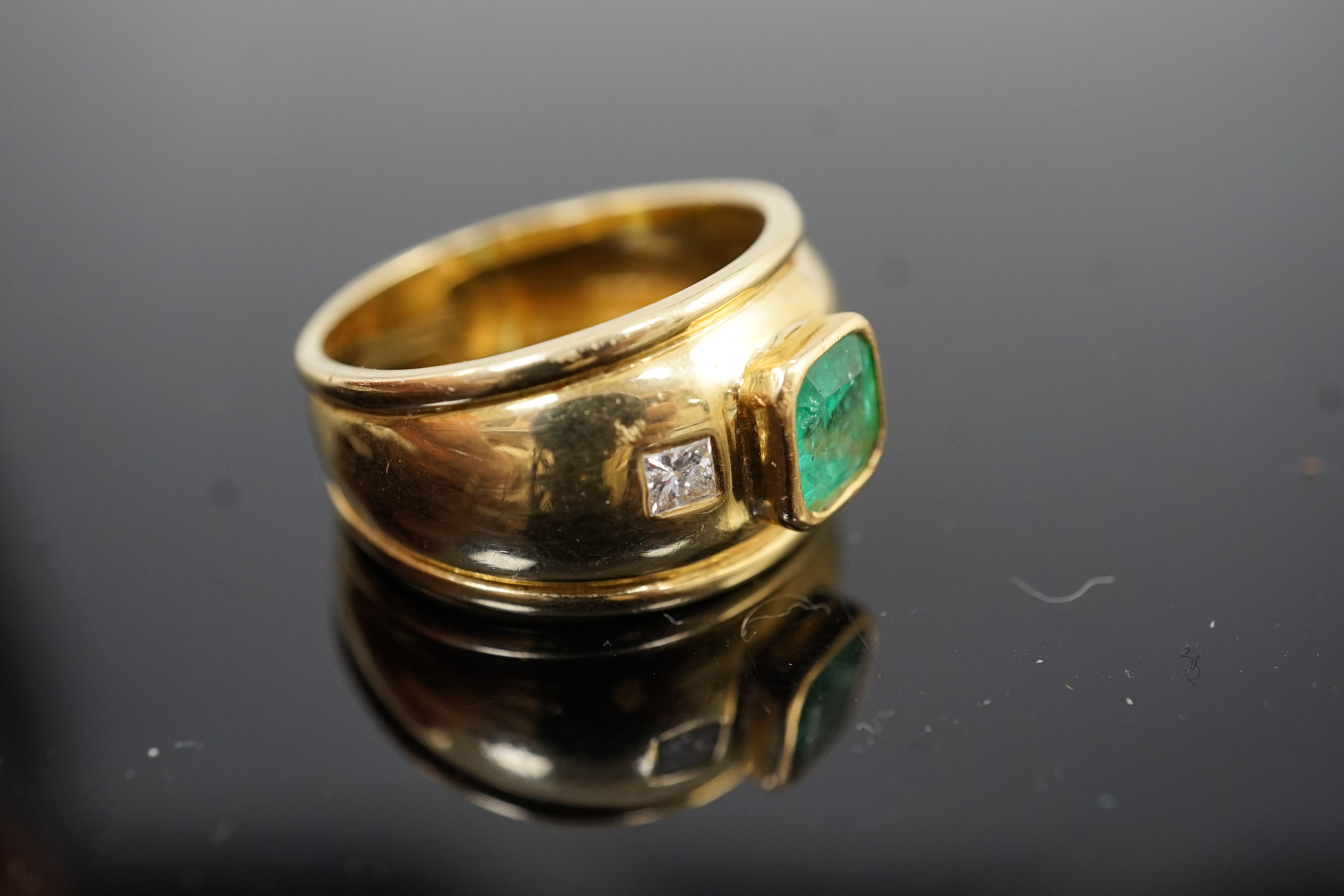 A modern Theo Fennel style 18ct gold, single stone collet set emerald and two stone gypsy set princess cut diamond dress ring